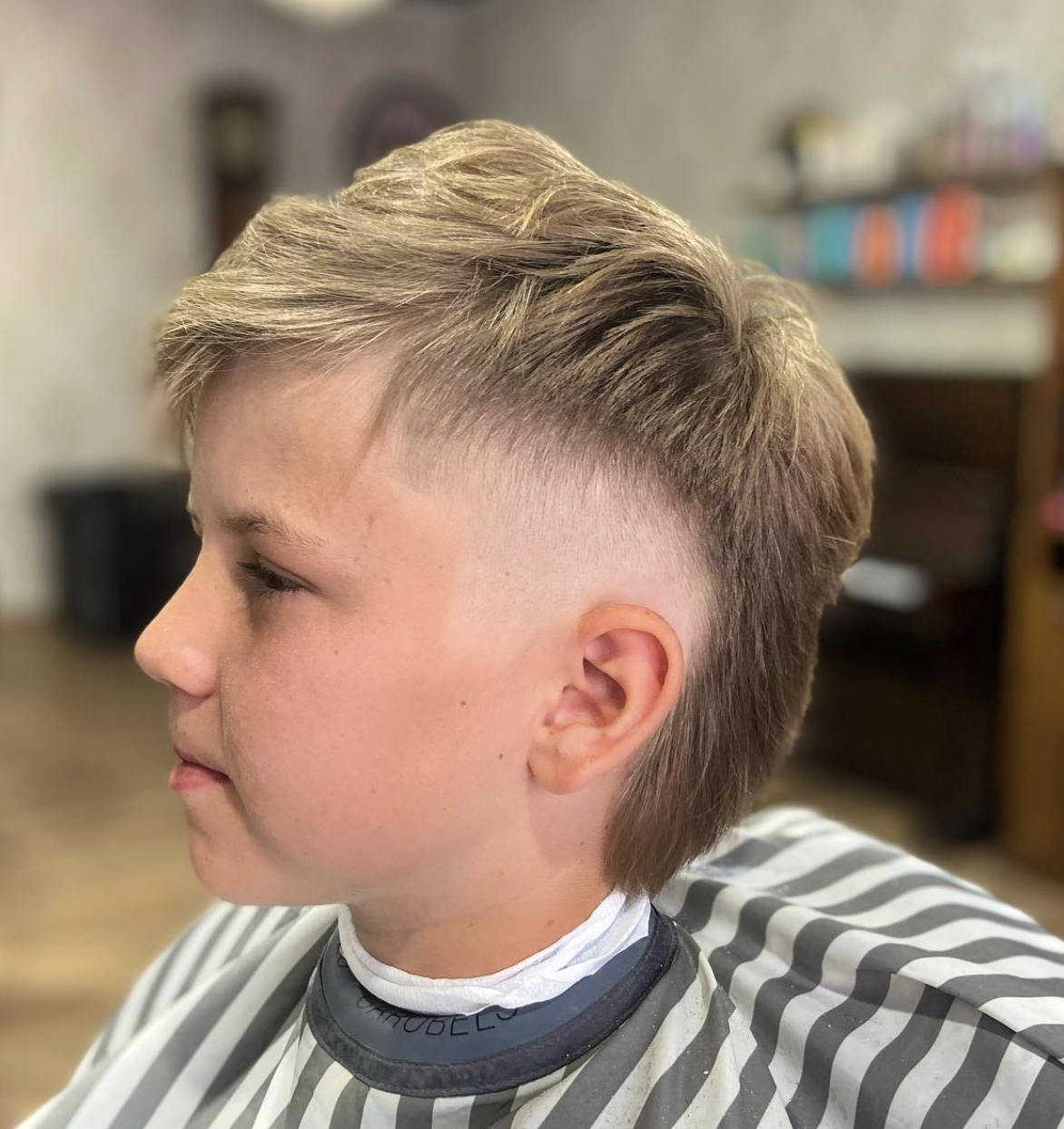 Youthful cut with a soft fade and polished finish done at The Barber's History